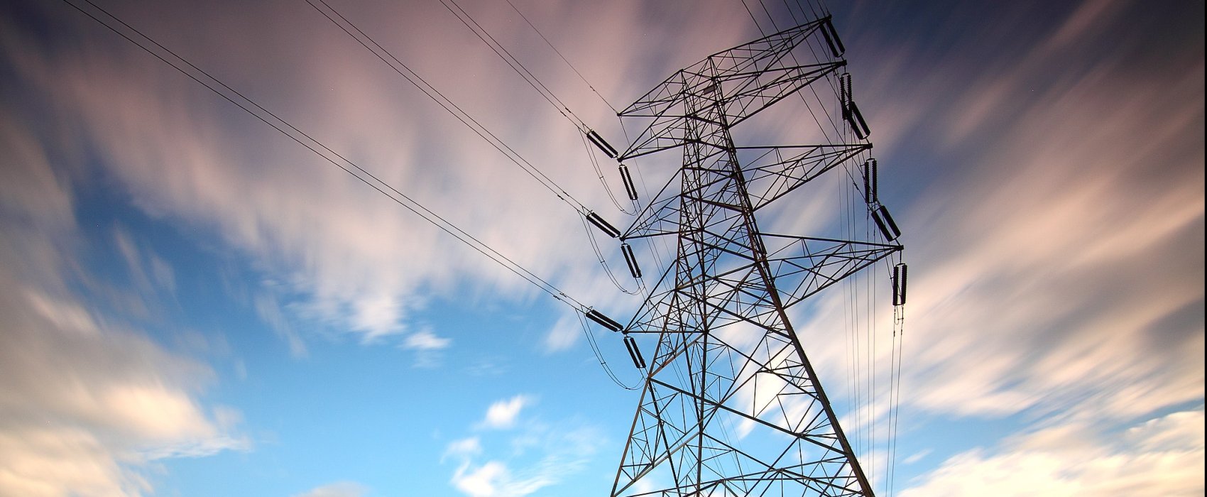 powerlines in front of a blue cloudy sky