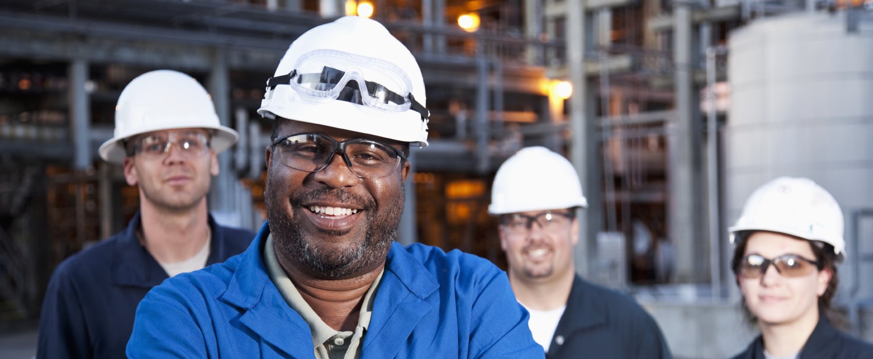 a group of smiling diverse workers in hardhats
