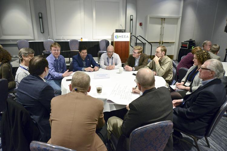 workshop attendees chat seated around a circular table