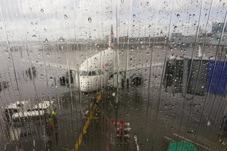 Rain on airport window overlooking plane