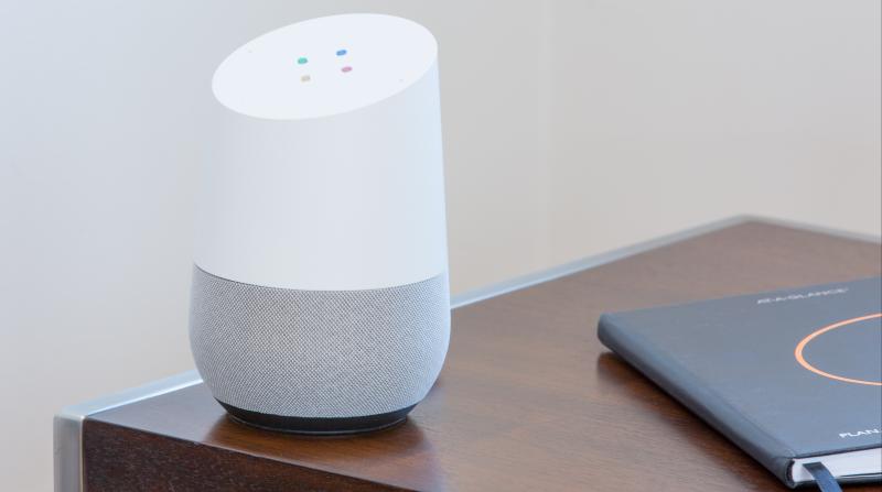 a google home smart speaker on a side table next to a planner